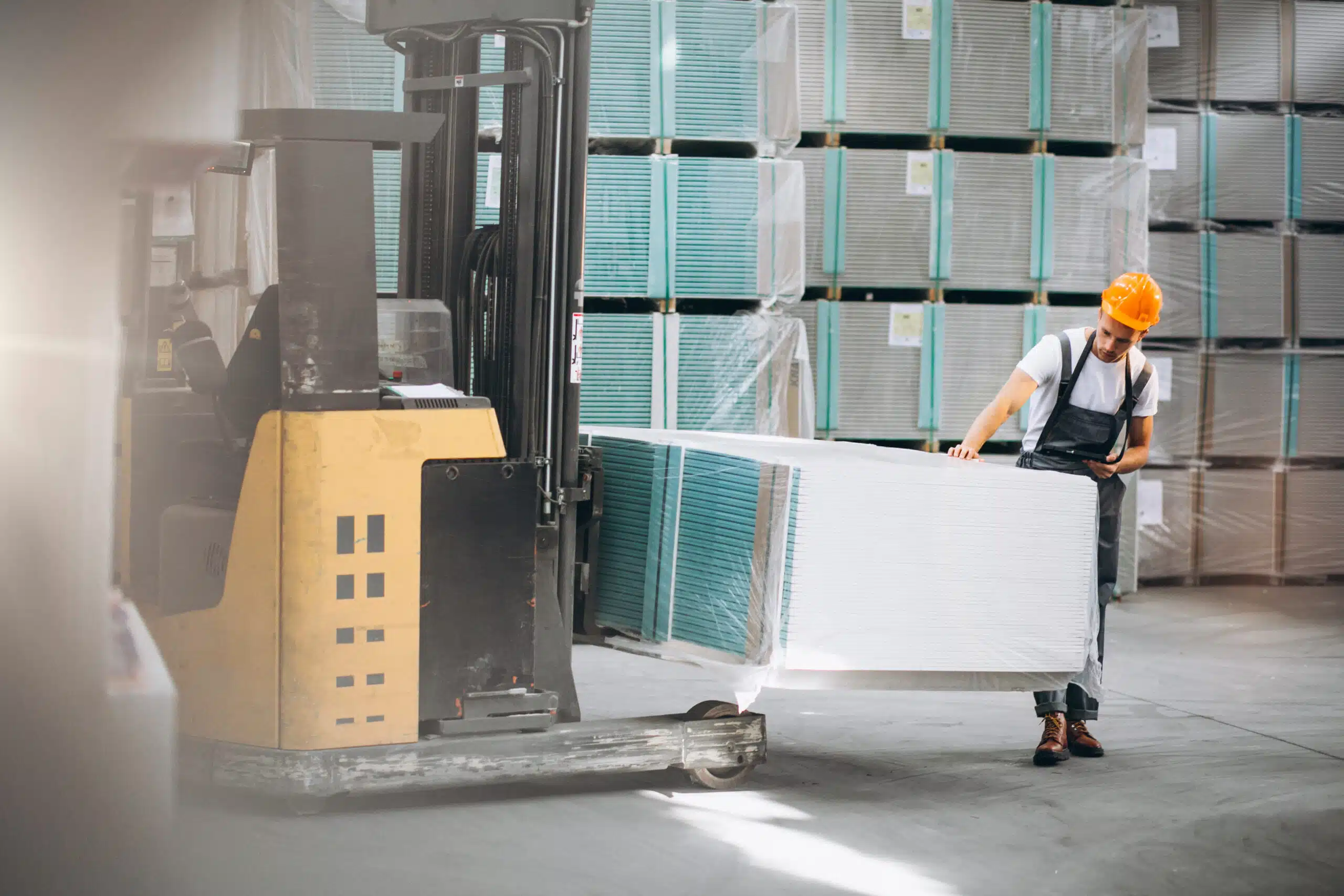 Traditional warehouse material handling with a forklift before implementing vertical lift modules for warehouse space optimization and phased automation.